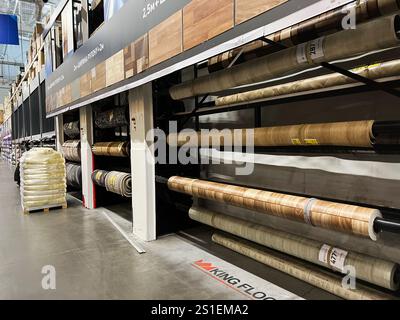 Kiev, Ukraine - 03 janvier 2025 : grands rouleaux de matériaux de revêtement de sol soigneusement disposés sur des étagères dans un environnement de magasin industriel bien éclairé. Banque D'Images