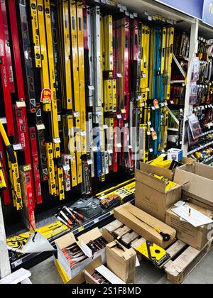 Kiev, Ukraine - 03 janvier 2025 : divers outils de mesure colorés sont disposés sur une étagère de quincaillerie, y compris des niveaux. Boîtes en carton et packa Banque D'Images