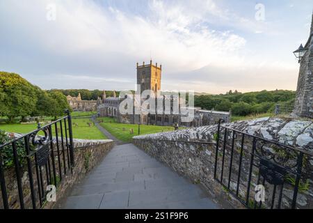 St David's Wales - 3 août 2024 ; lever du soleil depuis les marches menant à la cathédrale médiévale St David et aux ruines du palais des évêques en arrière-plan à Pembrokes Banque D'Images