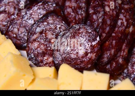 Tranches de saucisse sur planche de bois avec différentes collations. Tapas. Banque D'Images