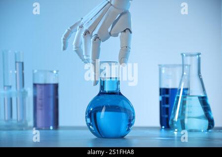Intelligence artificielle. Main de robot avec flacon à table en lumière bleue, gros plan Banque D'Images