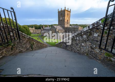 St David's Wales - 3 août 2024 ; lever du soleil depuis les marches menant à la cathédrale médiévale St David et aux ruines du palais des évêques en arrière-plan à Pembrokes Banque D'Images