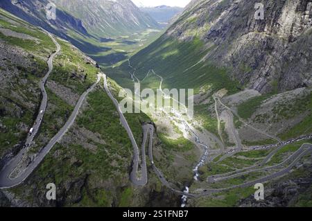 Une route sinueuse traverse une vallée verdoyante entre montagnes majestueuses, Trollstigen, Andalsnes, Norvège, Europe Banque D'Images