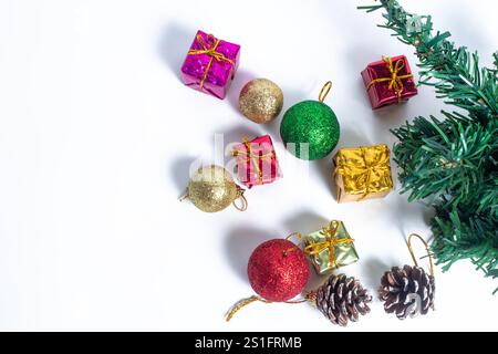 Un arrangement élégant d'ornements de vacances colorés, y compris des boules pailletées, de petites boîtes cadeaux, et des pommes de pin, branche d'arbre vert. Parfait pour CHRI Banque D'Images