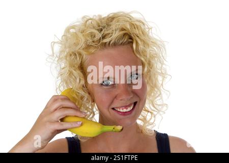 Jeune femme avec banane coupée sur fond blanc Banque D'Images
