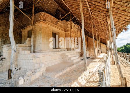 Décoration en stuc EK Balam Acropolis Yucatan Mexique // EK' BALAM, Mexique — la décoration en stuc élaborée à l'extérieur de l'Acropole présente des détails sculpturaux complexes maintenant protégés par une couverture de toit de chaume. La façade ornée entourant le tombeau d'Ukit Kan le'k Tok' présente des techniques artistiques mayas sophistiquées de la période classique tardive, avec une construction multicouche en stuc à la chaux construite plutôt que sculptée dans la pierre. Ek' Balam (également connu sous le nom d'Ek Balam) a atteint son apogée entre 770-840 EC en tant que capitale de l'ancien Royaume maya de Talol. Le site est situé au Mexique Banque D'Images