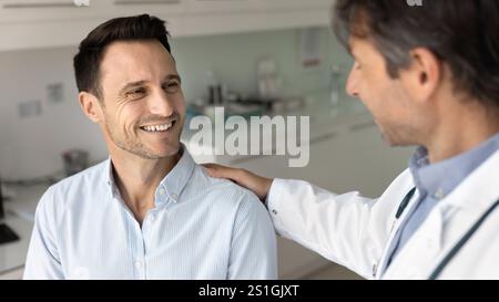 Heureux patient masculin obtenant du soutien, bonne nouvelle du docteur Banque D'Images
