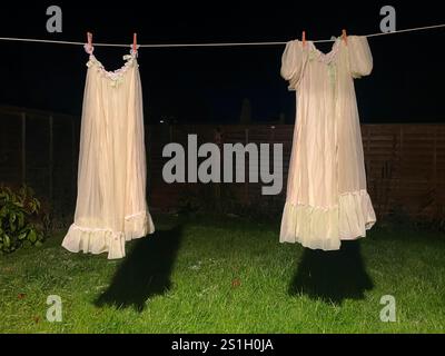 robe de chambre de nuit des années 1960 en tissu polyester nylon artificiel suspendu sur une ligne de lavage dans un jardin arrière à londres angleterre la nuit dans l'obscurité à l'air effrayant Banque D'Images