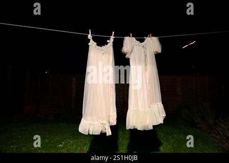 robe de chambre de nuit des années 1960 en tissu polyester nylon artificiel suspendu sur une ligne de lavage dans un jardin arrière à londres angleterre la nuit dans l'obscurité à l'air effrayant Banque D'Images