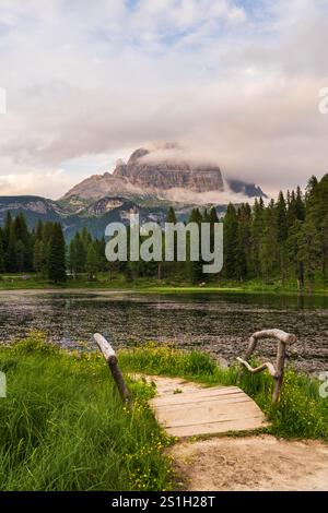 Paysage de Antorno lago avec les trois pics populaires de Lavaredo en arrière-plan. Petit pont en bois, montagnes dans les nuages. Tre Cime, Misurina, Cortin Banque D'Images