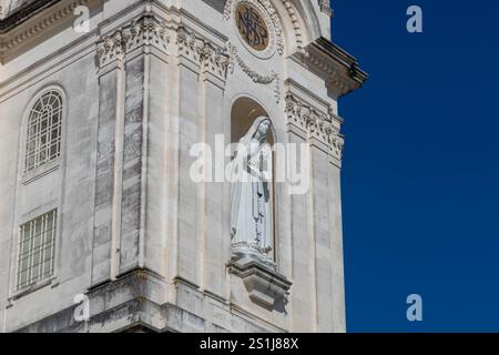 Détail du clocher avec image de notre dame de Rosaire avec chapelet et croix sur la façade de la basilique dans le sanctuaire de Fátima Portugal Banque D'Images