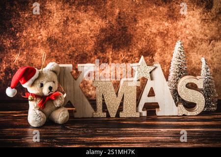 Petite peluche avec chapeau de père noël et lettres en bois de Noël, décoration de noël sur fond en bois, espace de copie Banque D'Images