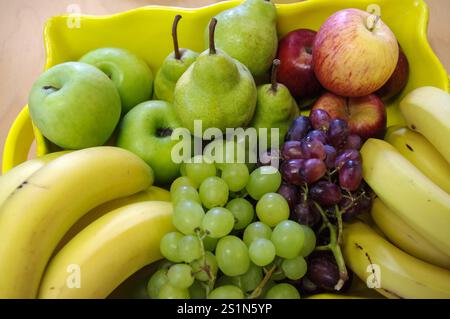 Une variété de fruits dans un plat jaune Banque D'Images