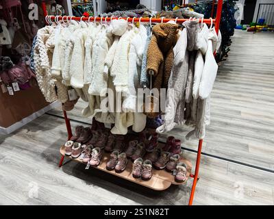 Kiev, Ukraine - 04 janvier 2025 : un magasin présentant des vestes et des bottes d'hiver pour enfants, illustrant des vêtements confortables et chauds. Banque D'Images