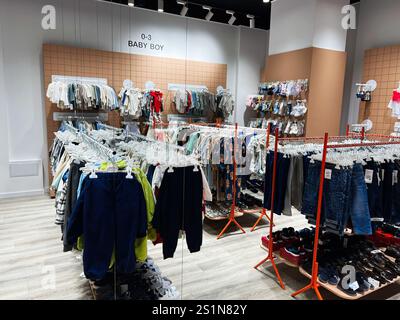 Kiev, Ukraine - 04 janvier 2025 : une section de magasin de détail bien organisée présentant des vêtements et des articles de chaussures pour bébés, classés par styles. Banque D'Images