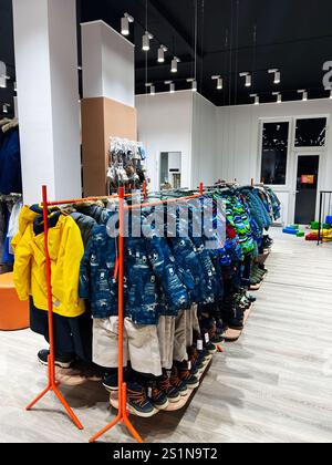 Kiev, Ukraine - 04 janvier 2025 : une variété de tenues d'hiver, bottes et vêtements d'extérieur pour enfants dans un cadre de vente au détail bien éclairé. Banque D'Images