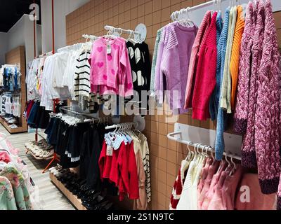 Kiev, Ukraine - 04 janvier 2025 : magasin de vêtements présentant une large gamme de pulls, chemises et chaussures colorés exposés sur des étagères. Banque D'Images