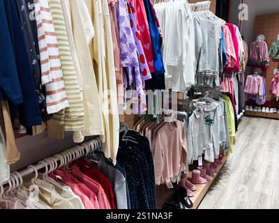 Kiev, Ukraine - 04 janvier 2025 : magasin de vêtements bien éclairé présentant divers vêtements pour enfants, disposés soigneusement sur des cintres. Banque D'Images