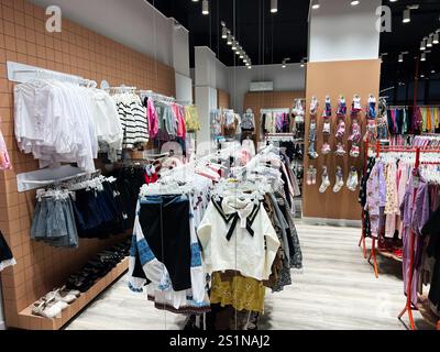 Kiev, Ukraine - 04 janvier 2025 : magasin de vêtements pour enfants bien organisé avec une variété de vêtements exposés, mettant en valeur la mode colorée. Banque D'Images