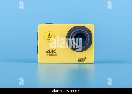Moscou, Russie - 3 janvier 2025:gros plan d'une caméra d'action Ultra HD 4K jaune avec fonction WiFi, affichée sur un fond bleu Uni, tech con Banque D'Images