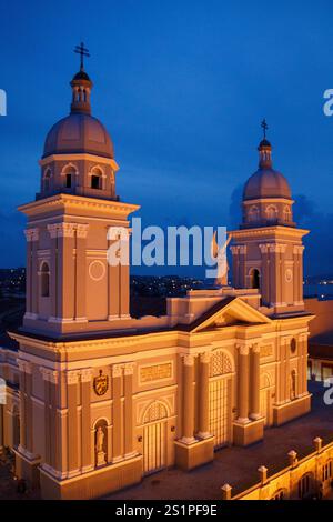 La cathédrale basilique de notre-Dame de l'Assomption façade avec ses tours jumelles et statue d'ange la nuit dans le Parque Cespedes, centre-ville de Santiago de Cu Banque D'Images