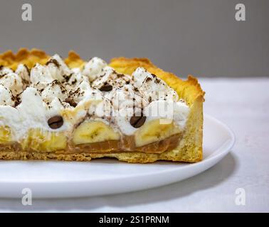 Gâteau banoffee traditionnel à la banane et à la sauce caramel saupoudrée de chocolat noir râpé et de café. Tarte traditionnelle anglaise Banque D'Images