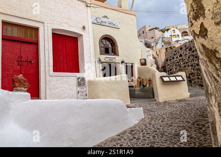 Rue traditionnelle méditerranéenne de village avec architecture historique et portes vibrantes, Santorin, Grèce Banque D'Images