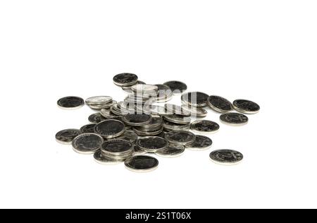 Une collection de pièces de monnaie variées se trouve de manière aléatoire sur une surface blanche, présentant des textures métalliques et des motifs complexes. Cette disposition met en évidence le Banque D'Images