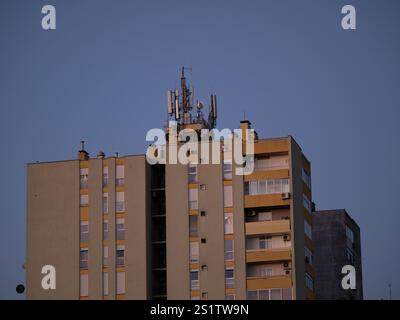 Antennes cellulaires et émetteurs sur le toit d'un bâtiment résidentiel. Équipement de transmission radio et lignes de communication sur le toit. Antennes 5G. Soirée Banque D'Images
