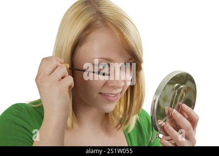 Jeune femme appliquant le maquillage - recadré sur blanc Banque D'Images