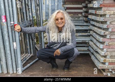 Femme agenouillée avec de longs cheveux bouclés entourent la zone de l'industrie Banque D'Images