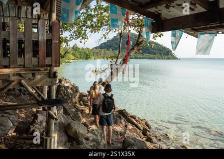 Koh Chang, Thaïlande. 03 janvier 2025. On voit des touristes marcher sur un sentier rocheux pour accéder à long Beach, sur l'île de Koh Chang. Long Beach sur Koh Chang est une plage isolée et pittoresque située à la pointe sud-est de Koh Chang, en Thaïlande. Connue pour sa beauté naturelle, son atmosphère paisible et son développement minimal, elle est une destination idéale pour ceux qui recherchent la tranquillité, sans internet et avec une électricité limitée des générateurs, pour se déconnecter et profiter de la nature. Crédit : SOPA images Limited/Alamy Live News Banque D'Images