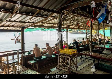 Koh Chang, Thaïlande. 03 janvier 2025. Vue générale d'un restaurant de plage en bois, en face de la mer, avec des touristes, à long Beach, sur l'île de Koh Chang. Long Beach sur Koh Chang est une plage isolée et pittoresque située à la pointe sud-est de Koh Chang, en Thaïlande. Connue pour sa beauté naturelle, son atmosphère paisible et son développement minimal, elle est une destination idéale pour ceux qui recherchent la tranquillité, sans internet et avec une électricité limitée des générateurs, pour se déconnecter et profiter de la nature. (Photo de Nathalie Jamois/SOPA images/SIPA USA) crédit : SIPA USA/Alamy Live News Banque D'Images