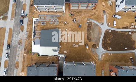 Vue aérienne d'un chantier de construction avec plusieurs bâtiments et véhicules. Banque D'Images