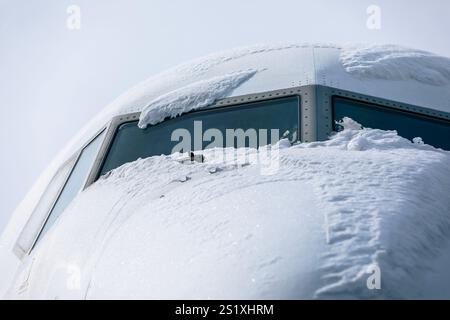 Cockpit recouvert de neige d'un avion de passagers avant le dégivrage. Journée d'hiver à l'aéroport. Banque D'Images