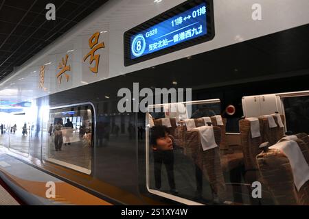 XI'an, Chine. 5 janvier 2025. Les passagers à bord du train G828 à destination de Hong Kong sont photographiés à la gare du Nord de Xi'an à Xi'an, province du Shaanxi au nord-ouest de la Chine, le 5 janvier 2025. Une ligne directe de train à grande vitesse a été lancée dimanche entre Xi'an, la capitale de la province du Shaanxi, au nord-ouest de la Chine, et la région administrative spéciale de Hong Kong. Crédit : Xinhua/Alamy Live News Banque D'Images