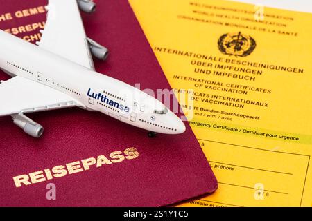 Flugreise mit Reisepass und Impfbuch Ein Modellflugzeug der Lufthansa steht auf einem Deutschen Reisepass und einem Impfbuch *** voyage aérien avec passp Banque D'Images