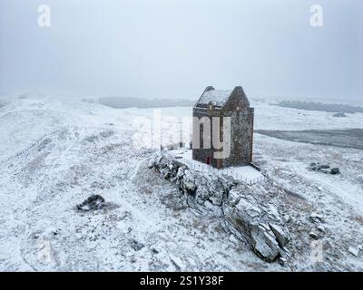 Kelso, Écosse, Royaume-Uni. 5 janvier 2025. La neige tombe sur une grande partie du sud de l'Écosse dans les Scottish Borders et Dumfries et Galloway aujourd'hui. Pic ; la tour Smailholm du 15ème siècle près de Kelso dans Scottish Borders dans un paysage couvert de neige sombre. Iain Masterton/Alamy Live News Banque D'Images