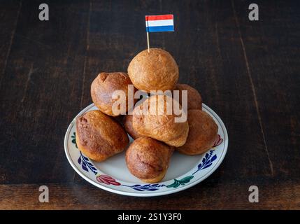 Pile d'oliebollen hollen traditionnel sur l'assiette décorée avec le drapeau hollandais Banque D'Images