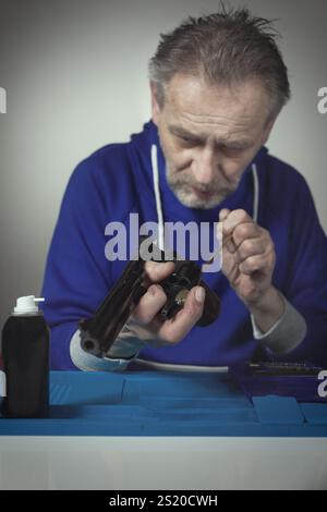 Homme prendre soin de revolver de six pouces calibre .357 magnum à la maison Banque D'Images