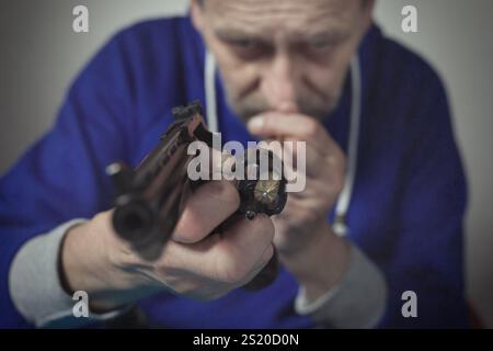 Homme prendre soin de revolver de six pouces calibre .357 magnum à la maison Banque D'Images