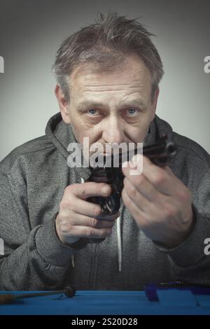 Homme prendre soin de revolver de six pouces calibre .357 magnum à la maison Banque D'Images