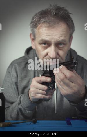 Homme prendre soin de revolver de six pouces calibre .357 magnum à la maison Banque D'Images