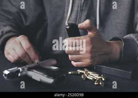 Homme chargeant mgazine de pistolet semi-automatique à la maison Banque D'Images