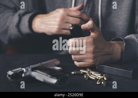 Homme chargeant mgazine de pistolet semi-automatique à la maison Banque D'Images