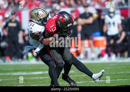 Tampa Bay, Floride, États-Unis, 5 janvier 2025, le récepteur Mike Evans #13 des Buccaneers de Tampa Bay est attaqué par Jordan Howden #31 au Raymond James Stadium. (Crédit photo : Marty Jean-Louis/Alamy Live News Banque D'Images