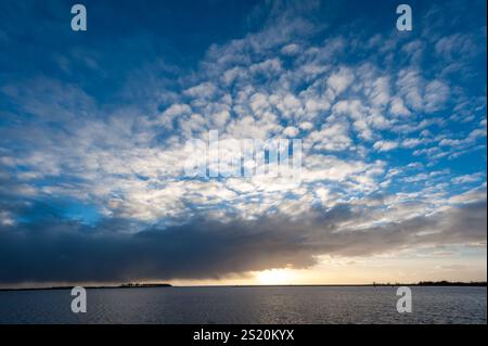 Impression d'un coucher de soleil sur une soirée d'hiver glaciale relativement froide dans la province néerlandaise de Frise. L'image est près de la ville de lemmer et la pompe à eau classique à vapeur woudagemaal. Banque D'Images