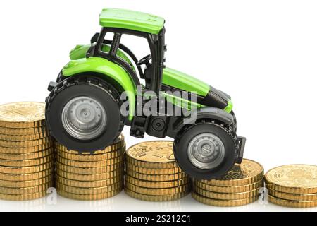 Les agriculteurs du secteur agricole sont confrontés à une augmentation des coûts. Des prix plus élevés pour les aliments pour animaux, les engrais et les plantes. Tracteur avec pièces de monnaie Banque D'Images