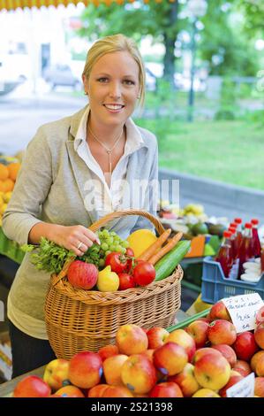 Une jeune femme achète des fruits et légumes sur un marché hebdomadaire. Nourriture fraîche et saine. Autriche Banque D'Images