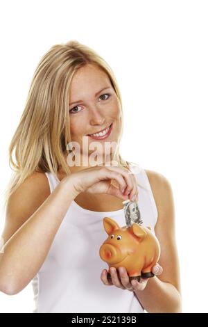 Une jeune femme économise de l'argent et des pièces pour l'avenir. Provision de retraite et épargne avec Dollar Bill Autriche Banque D'Images